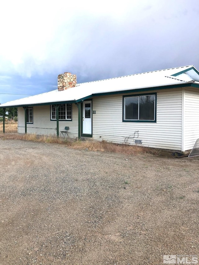 view of front of house with metal roof and a chimney