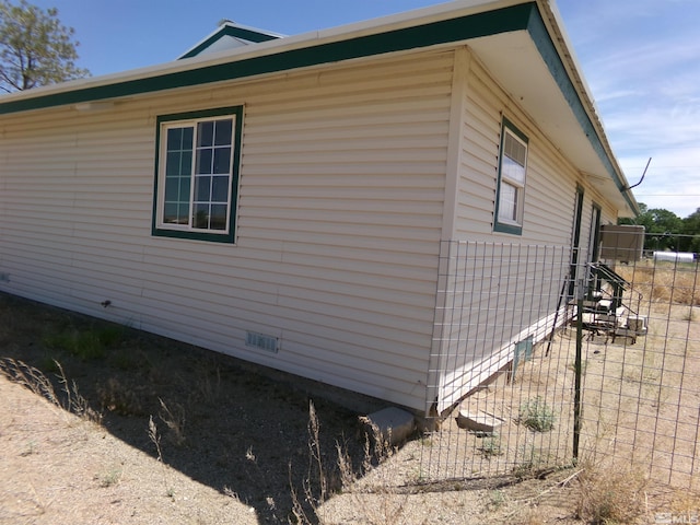 view of property exterior with crawl space and fence