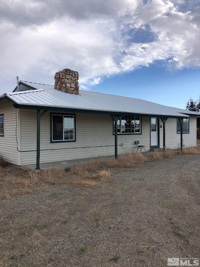 view of front of home featuring metal roof and a chimney