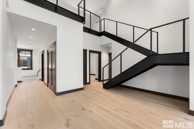 stairway with a high ceiling and hardwood / wood-style flooring