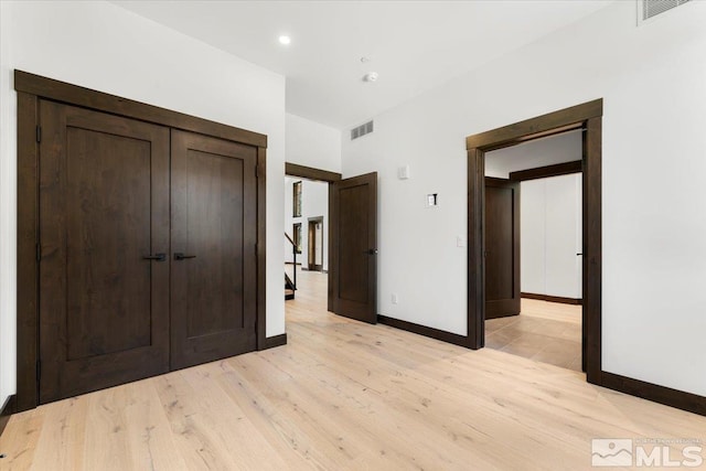 unfurnished bedroom featuring light hardwood / wood-style floors and a closet