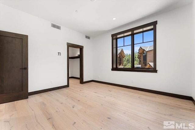 empty room with light hardwood / wood-style flooring