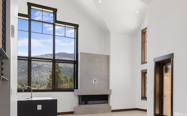 unfurnished living room with light hardwood / wood-style floors, high vaulted ceiling, and a healthy amount of sunlight