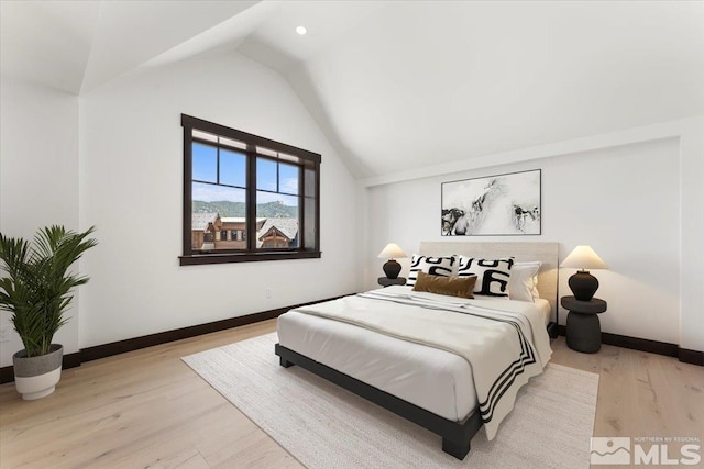 bedroom with light hardwood / wood-style flooring and lofted ceiling