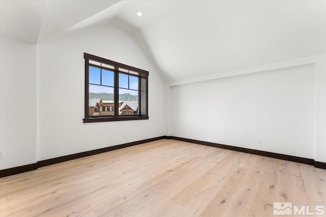 additional living space featuring light hardwood / wood-style flooring and lofted ceiling