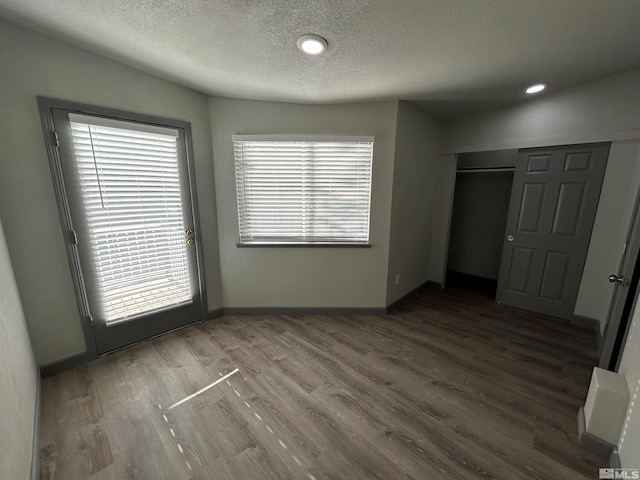 unfurnished bedroom with hardwood / wood-style flooring, a closet, and a textured ceiling