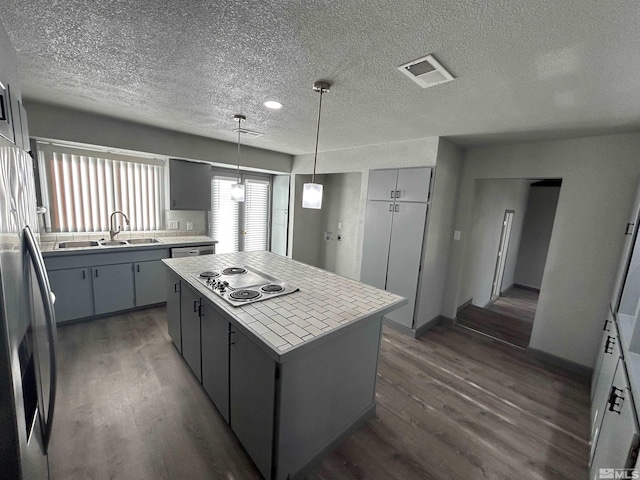 kitchen featuring a center island, sink, appliances with stainless steel finishes, and dark hardwood / wood-style flooring