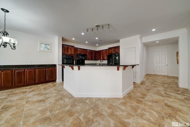 kitchen with a notable chandelier, an island with sink, pendant lighting, a kitchen bar, and black appliances