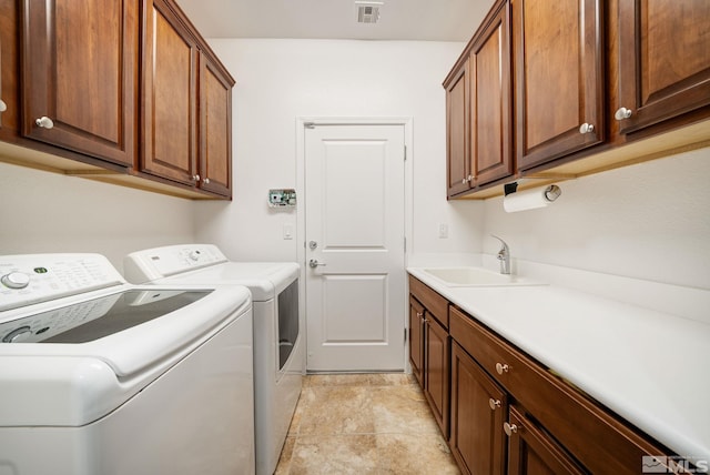 laundry room featuring washing machine and dryer, sink, and cabinets