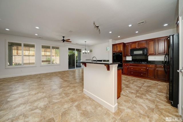 kitchen featuring pendant lighting, a breakfast bar, a kitchen island with sink, black appliances, and sink