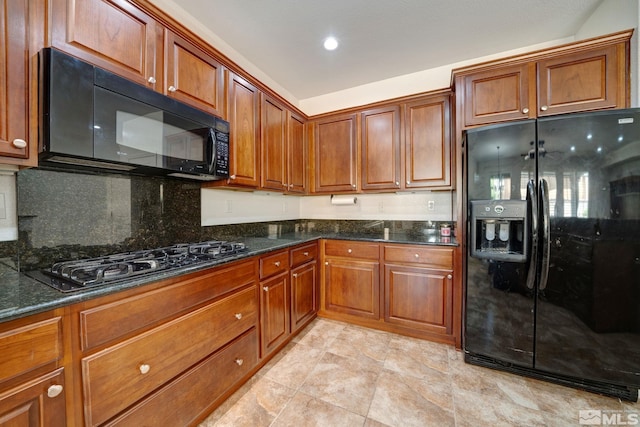 kitchen featuring dark stone counters, backsplash, and black appliances