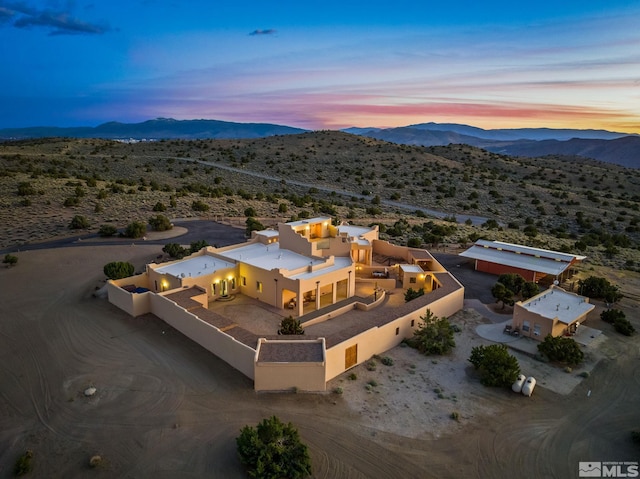 aerial view at dusk featuring a mountain view