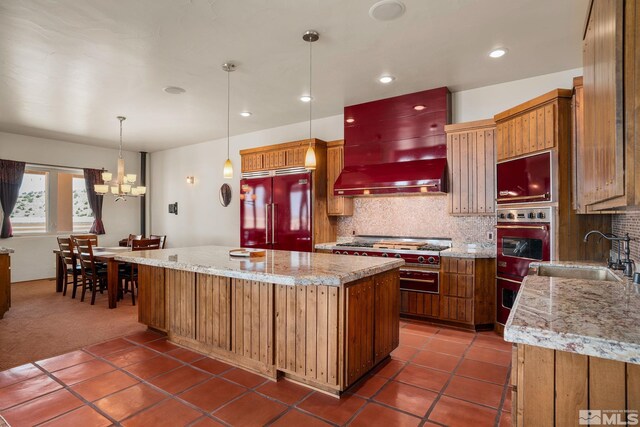 kitchen with premium range hood, a large island, backsplash, sink, and appliances with stainless steel finishes