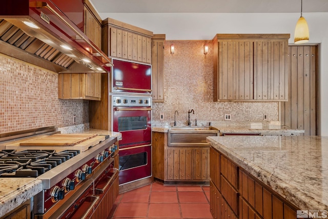 kitchen with dark tile flooring, custom range hood, stovetop, and tasteful backsplash