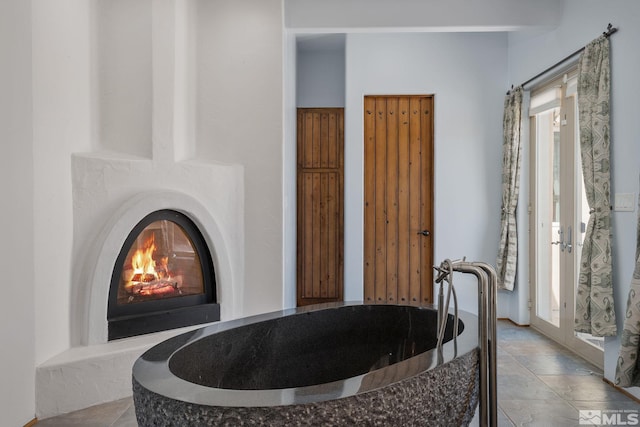 bathroom featuring a bath and tile floors