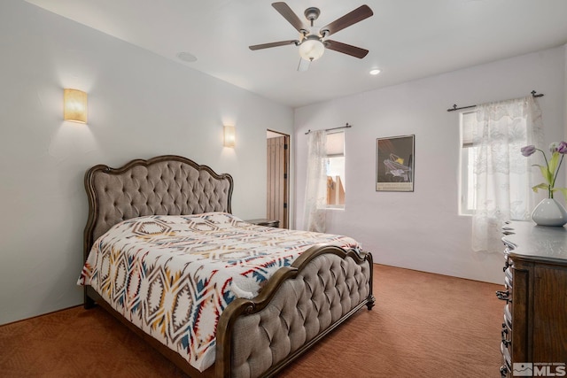 carpeted bedroom featuring ceiling fan and multiple windows