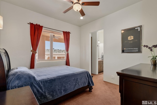 bedroom with light carpet, ceiling fan, and ensuite bath