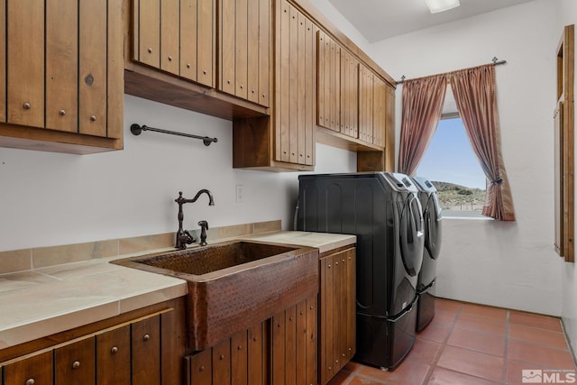 washroom with washer and clothes dryer, cabinets, and light tile flooring