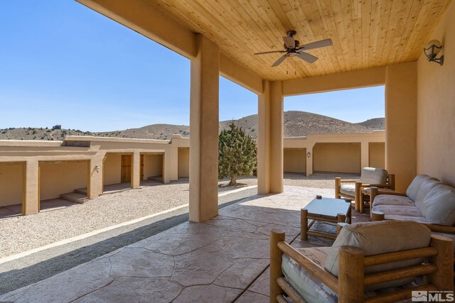 view of terrace with an outdoor living space, a mountain view, and ceiling fan