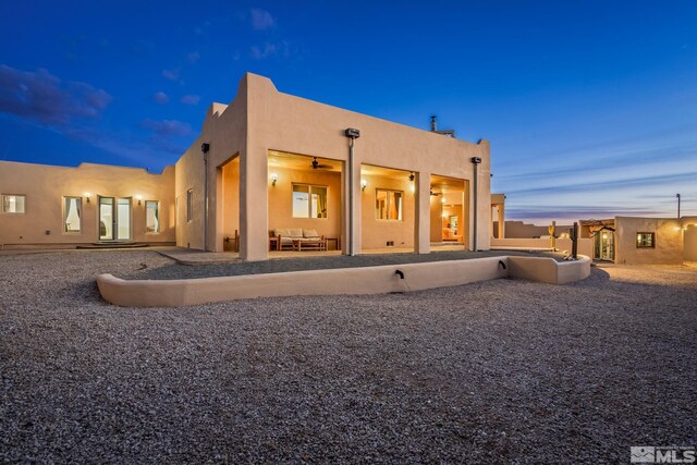 back house at dusk with a patio area