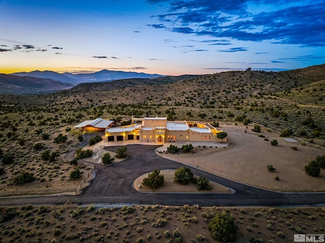 aerial view at dusk featuring a mountain view