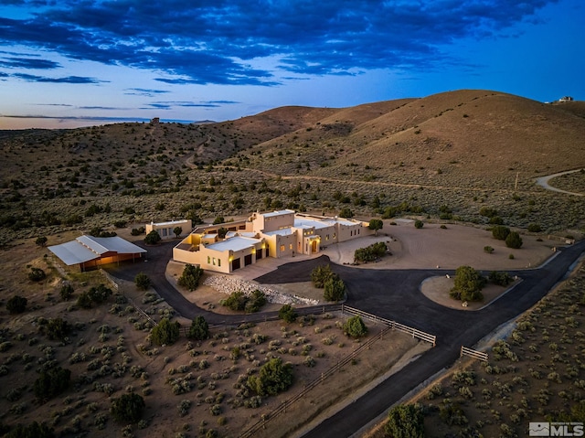 aerial view at dusk featuring a mountain view