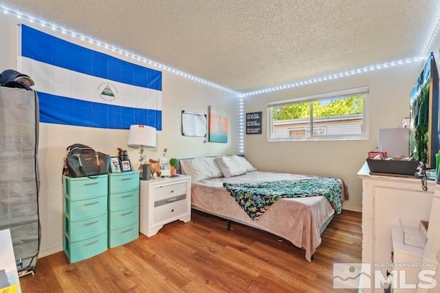 bedroom featuring a textured ceiling and hardwood / wood-style flooring