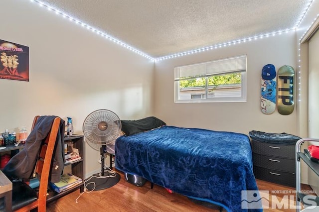 bedroom featuring hardwood / wood-style floors and a textured ceiling