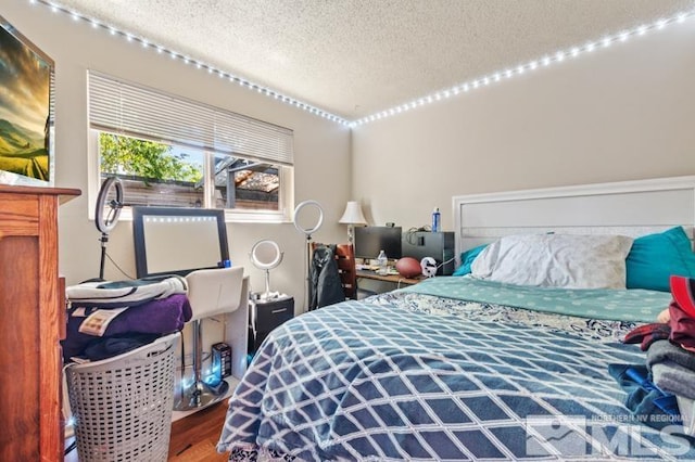 bedroom featuring wood-type flooring and a textured ceiling