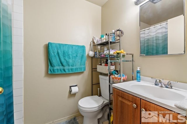 bathroom with curtained shower, vanity, and toilet