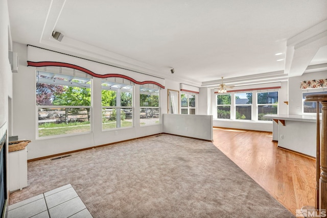 unfurnished living room with ceiling fan, plenty of natural light, and light hardwood / wood-style flooring