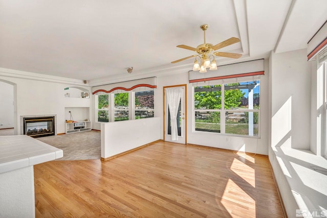 unfurnished living room featuring ceiling fan and light hardwood / wood-style flooring