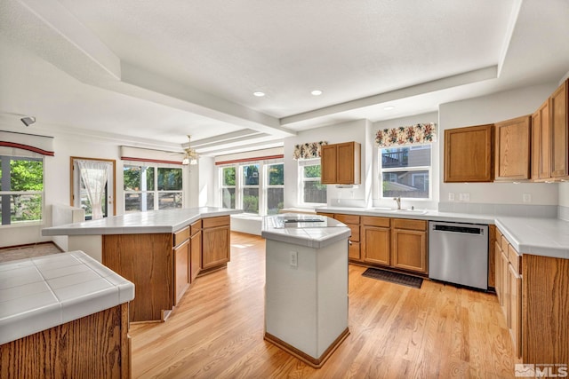 kitchen with kitchen peninsula, sink, dishwasher, light hardwood / wood-style floors, and a kitchen island