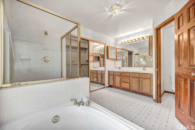 bathroom with a stall shower, a garden tub, toilet, and double vanity