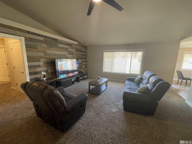 carpeted living room with ceiling fan, lofted ceiling, and wooden walls