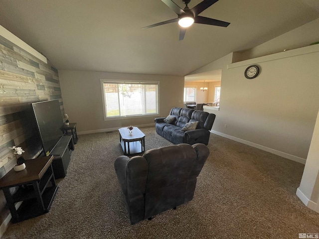 carpeted living room featuring ceiling fan, wooden walls, and vaulted ceiling