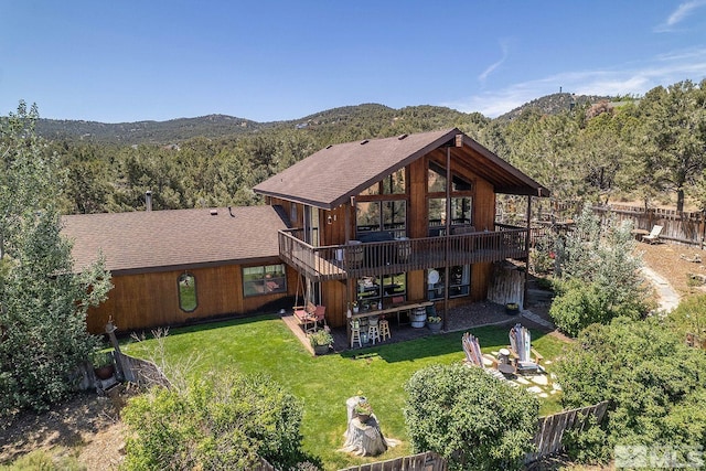 back of property featuring a lawn, a deck with mountain view, a patio, and exterior bar