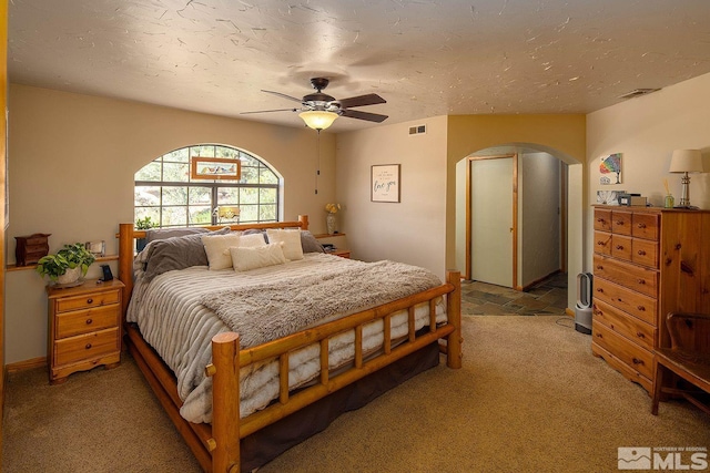 bedroom with light carpet, a textured ceiling, and ceiling fan