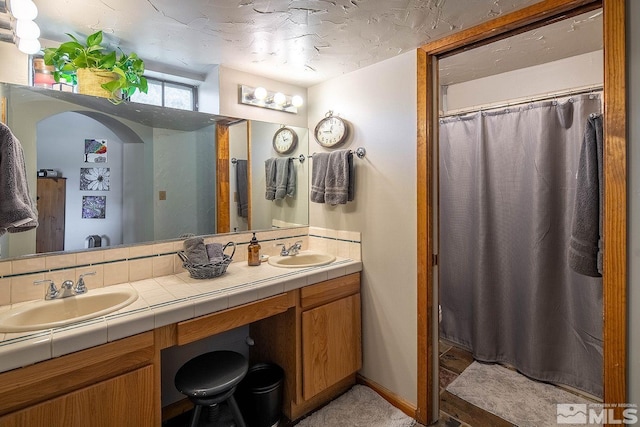 bathroom featuring a shower with shower curtain and vanity