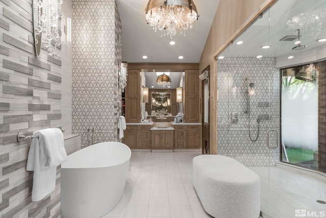 bathroom with vanity, tile walls, an inviting chandelier, and plus walk in shower