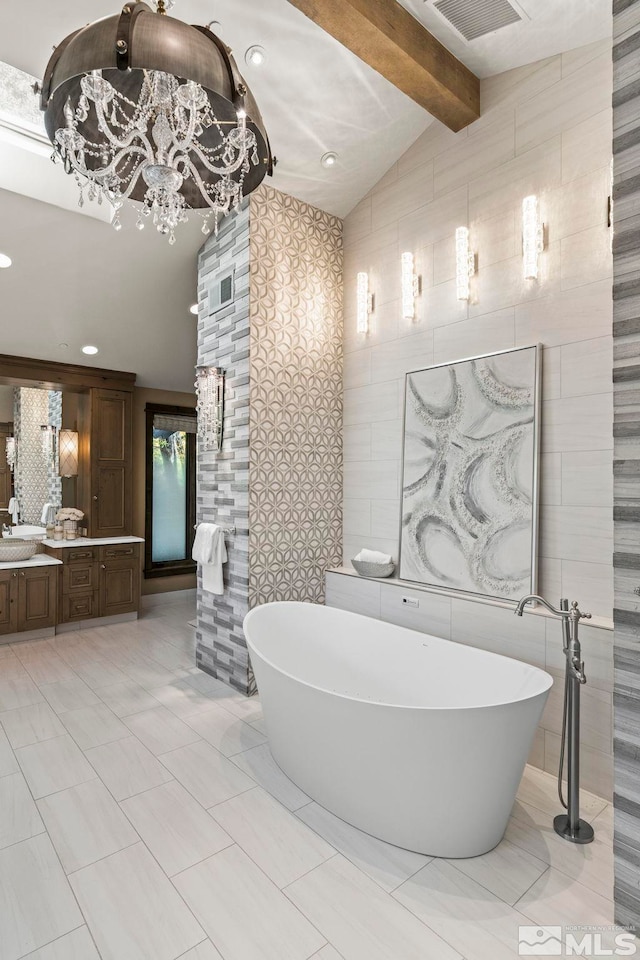 bathroom with vanity, tile walls, lofted ceiling with beams, a notable chandelier, and a bathing tub