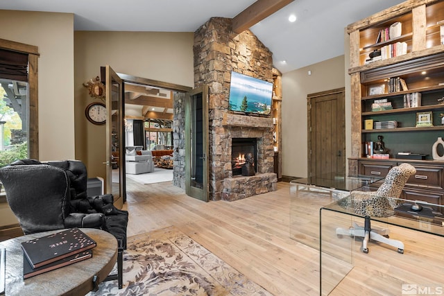 office space with light hardwood / wood-style floors, a fireplace, and vaulted ceiling with beams