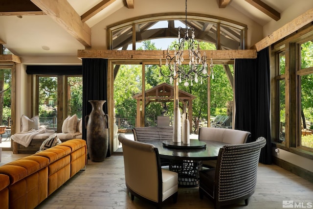 sunroom featuring an inviting chandelier and vaulted ceiling with beams