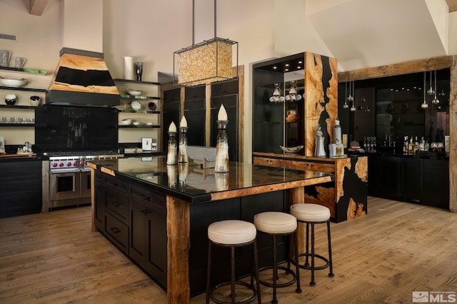 kitchen with double oven range, light hardwood / wood-style flooring, a breakfast bar area, and a kitchen island