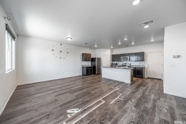 kitchen featuring stainless steel appliances, dark hardwood / wood-style flooring, a kitchen island with sink, and dark brown cabinetry