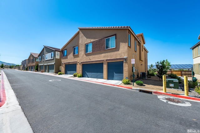 view of front of property featuring a garage and central air condition unit