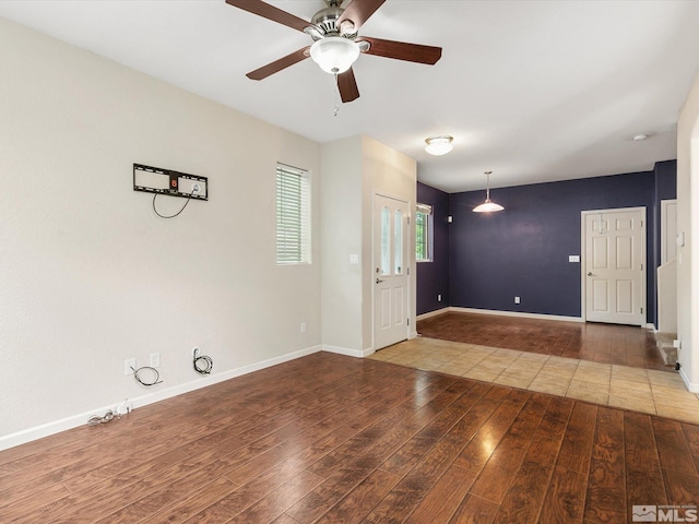 unfurnished room featuring ceiling fan and dark wood-type flooring