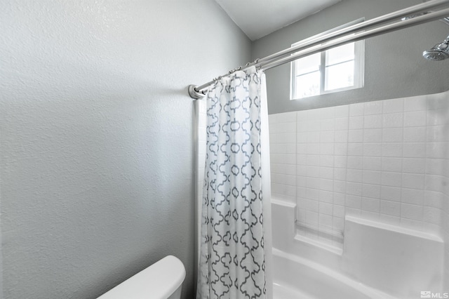 bathroom featuring toilet and shower / tub combo with curtain