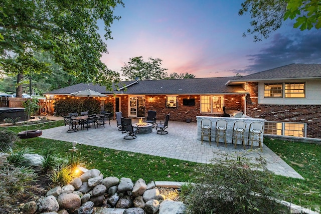 back house at dusk with a patio and an outdoor fire pit