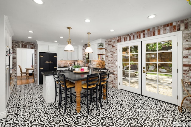 dining room featuring french doors and brick wall